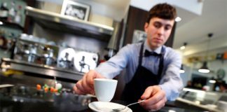 An Italian waiter practises 'social distancing.'