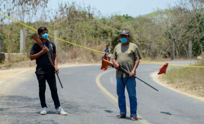 One of many checkpoints controlling access to communities across Mexico. The firearms would indicate they're serious.