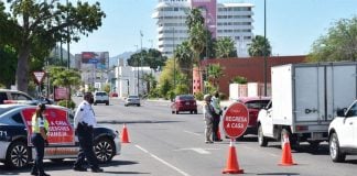 'Return home,' reads the sign at a checkpoint in Sonora.