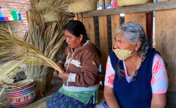 An artisan in Oaxaca wears one of the face masks made from palm leaves.