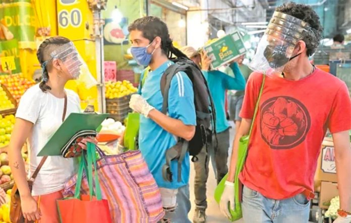 Three members of the Do Tribu team shopping at a market.