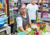 A woman attends to customers at a small Mexican corner store