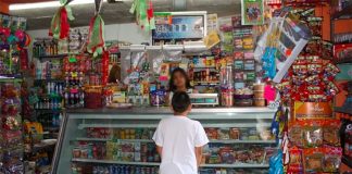 A child makes a purchase at a Mexican tiendita or corner store