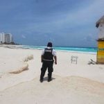 A police officer patrols an empty beach in Cancún