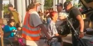 An armed man hands out provisions in Zapopan, Jalisco.