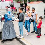 Cocinamos volunteers distribute food.