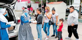 Cocinamos volunteers distribute food.