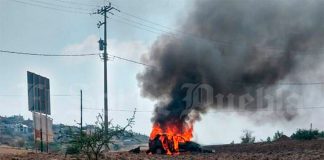 The vehicle in which lynching victims had traveled burns in Puebla.
