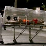 Paramedics move a Covid-19 patient.