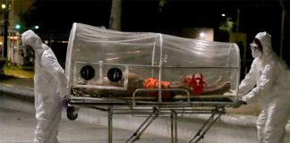 Paramedics move a Covid-19 patient.