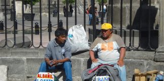 Agency predicts millions more will join ranks of the poor, such as these laborers looking for work.