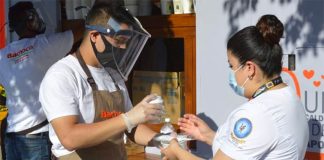 A Bachoco employee serves chicken soup to a healthcare worker.