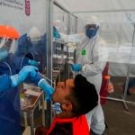 A healthworker administers a coronavirus test.