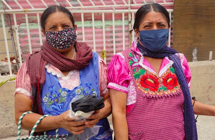 Women distribute face masks in Tlapazola, Oaxaca.