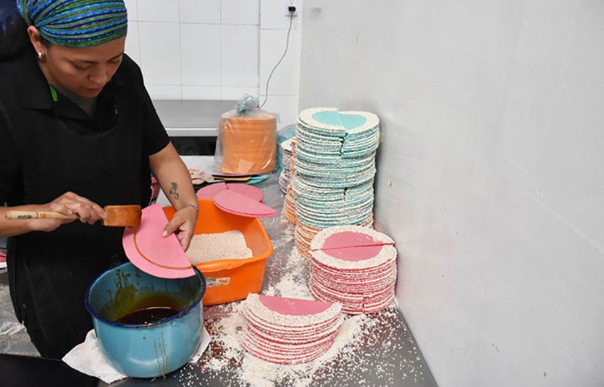 A woman makes amaranth wafers called obleas.