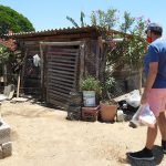 A Vallarta Food Bank volunteer delivers a food package to a needy recipient.