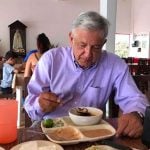 The president tucks into a meal of traditional food.