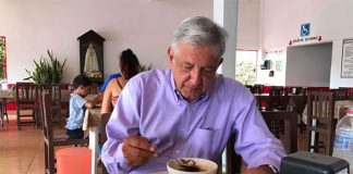 The president tucks into a meal of traditional food.