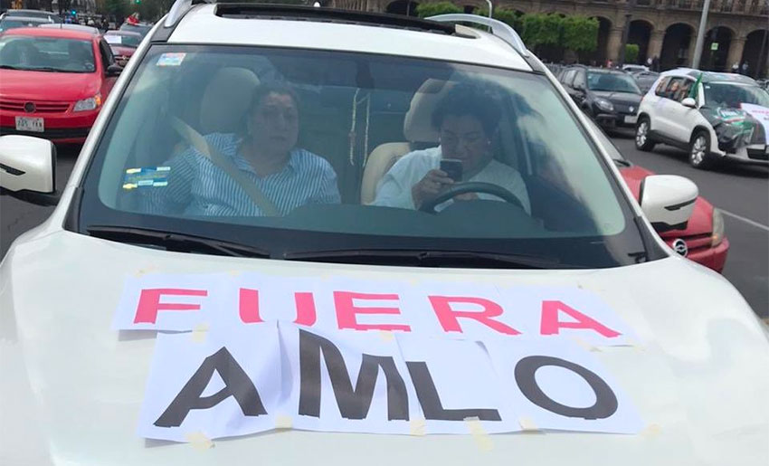 'AMLO out,' reads protesters' sign.