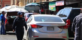 A traffic cop eyes a double-parked car in Oaxaca city.