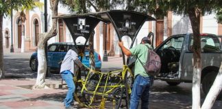Workers remove a park bench from the Plaza de Armas in Lerdo, Durango.