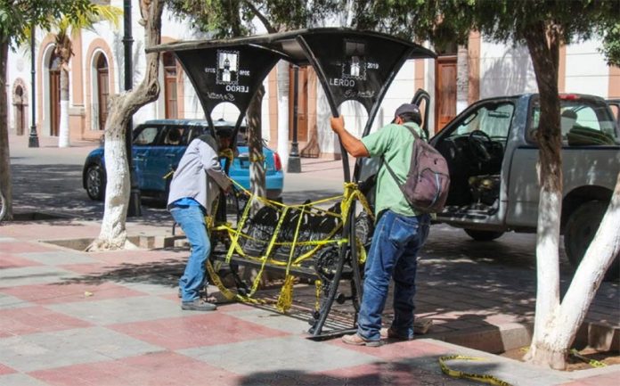 Workers remove a park bench from the Plaza de Armas in Lerdo, Durango.