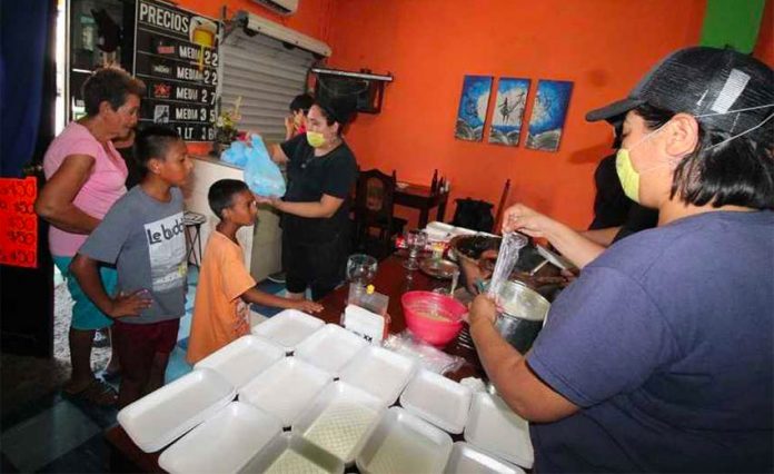 Staff at La Posta hand out meals to needy neighbors in Tampico.