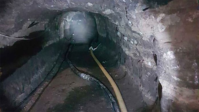 Hoses transport fuel in a petroleum thieves' tunnel.