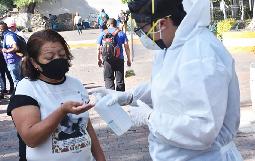 A healthcare worker dispenses gel in San Gregorio Atlapulco.