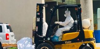 A forklift transports the body of a coronavirus victim