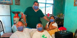 #LordPhotoshop, seated at left, posted digitally altered photos to Facebook, adding masks to people's faces.