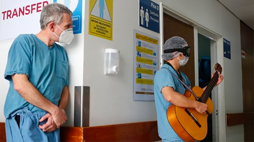 A hospital worker listens as Coss entertains staff and patients.