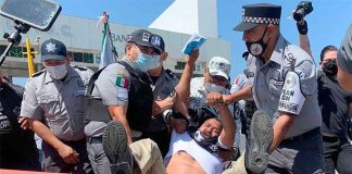 Security forces arrest a protester at the toll plaza on Thursday.