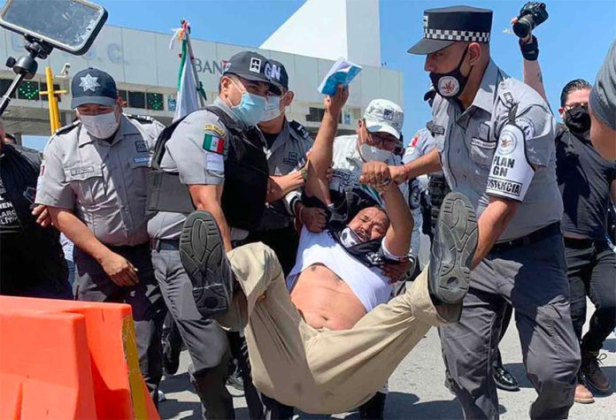 Security forces arrest a protester at the toll plaza on Thursday.