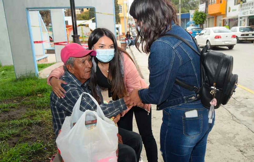 Rodríguez gets a hug from a young woman delivering a bag of supplies.