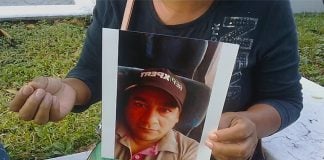 Andrade with a photo of her late husband, whose body was mistaken for that of another virus victim.