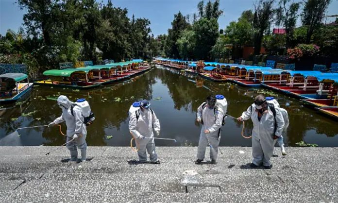 Workers disinfect a walkway in Xochimilco, Mexico City.