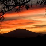 The sun sets behind Tequila Volcano.