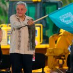 The president waves the starter's flag at inauguration of construction of the Maya Train in June.