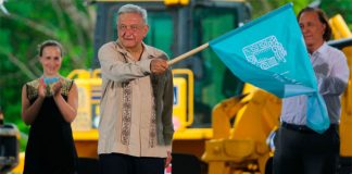 The president waves the starter's flag at inauguration of construction of the Maya Train in June.