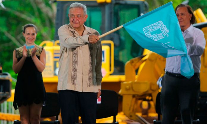 The president waves the starter's flag at inauguration of construction of the Maya Train in June.