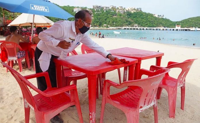 A waiter prepares a table at one of Huatulco's beaches.