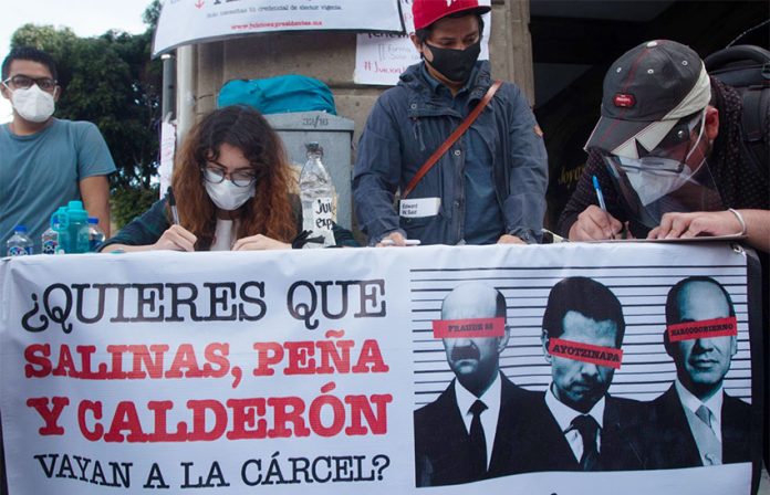 'Do you want Salinas, Peña and Calderón to go to jail?' reads the sign at a table gathering signatures for the Morena party petition.