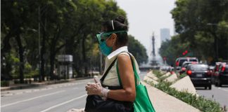 With a mask, goggles and gloves, a woman crosses the street in Mexico City.