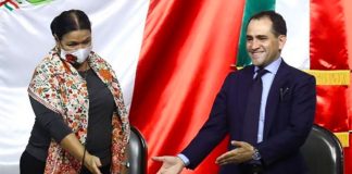 Dulce María Sauri, president of the executive board of the lower house of Congress, accepts budget documents from Finance Minister Arturo Herrera.