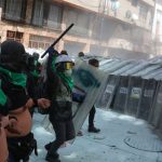 Shield-bearing police meet bare-chested protesters in Mexico City Sunday.