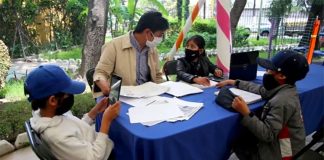 Jair helps his children with their studies at a park in Venustiano Carranza.
