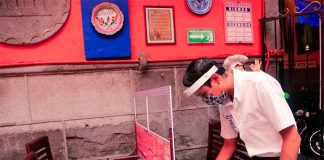 A waiter cleans a table with a coronavirus partition at a bar in Mexico City.