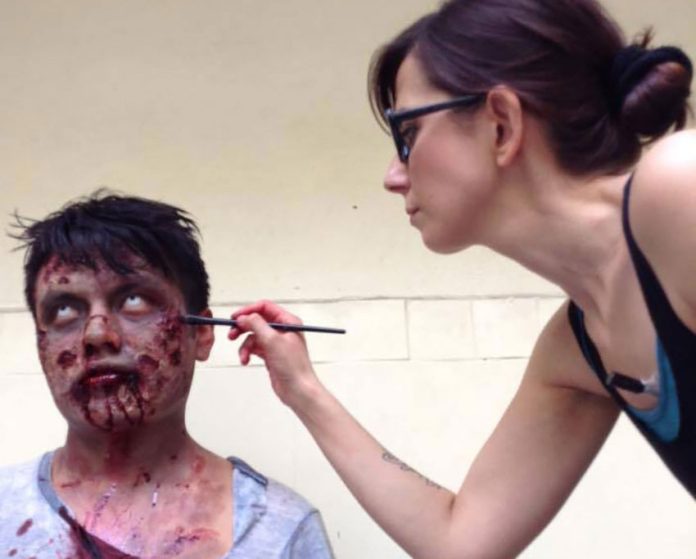 Francesca Dalla works on a zombie figure for a movie prop.