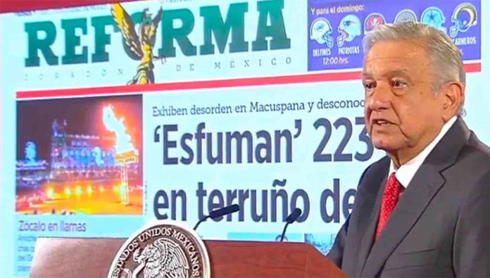 The president exhibits a front page of Reforma over a story with which he took issue, a common occurrence at his daily press conferences.